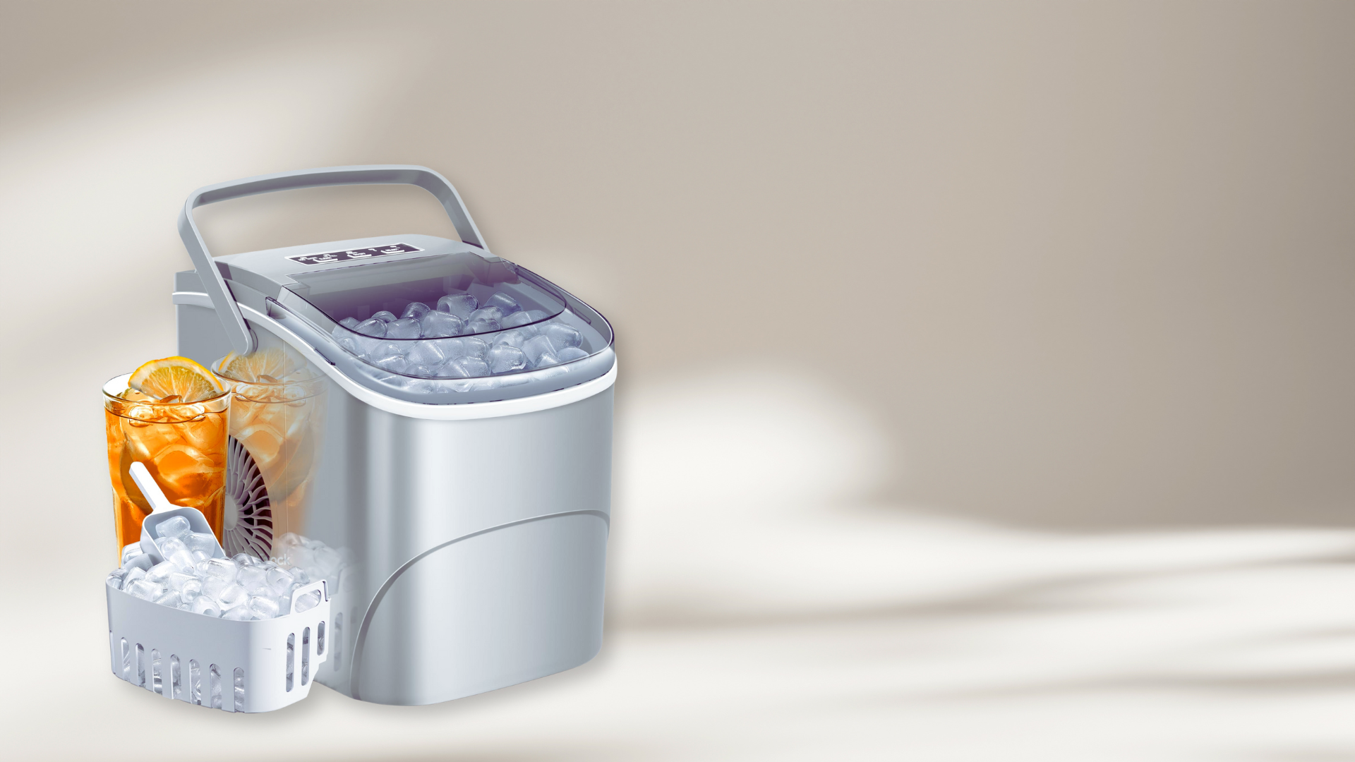 A silver countertop ice maker with a basket of ice and one iced drink in front.