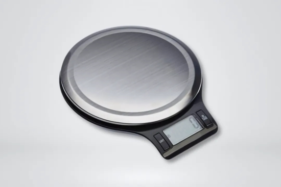 Black and silver Digital kitchen scale on a solid gray background