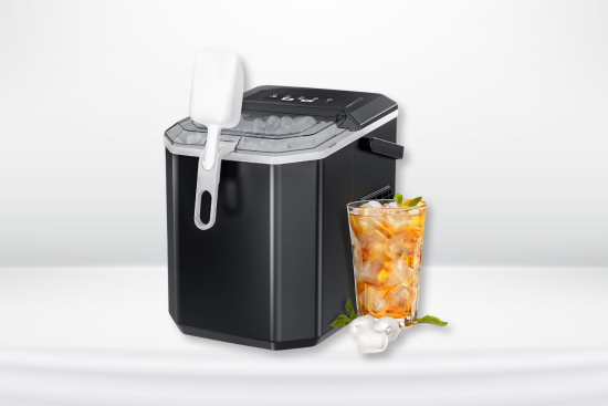 A black countertop ice maker with an ice scoop attached, alongside a glass of iced beverage garnished with mint leaves.