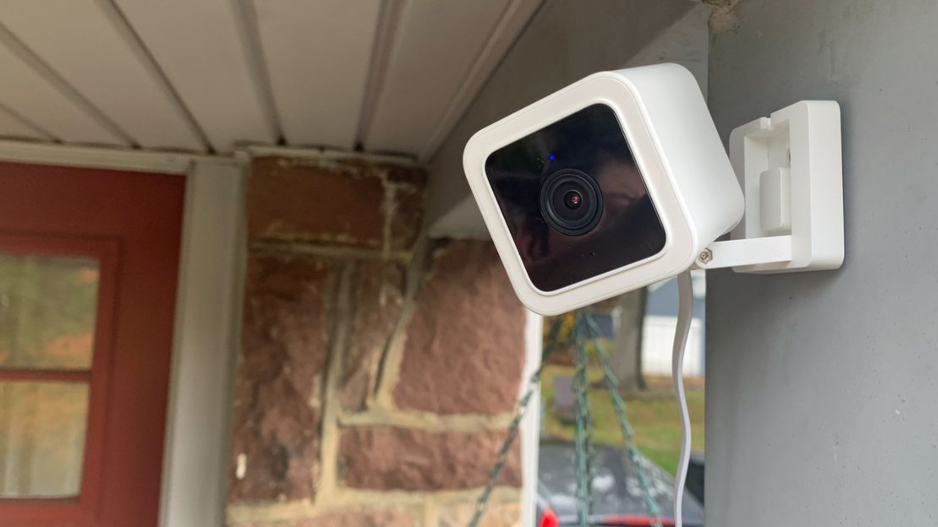 White compact security cameras placed on a wall in an outdoor garage.