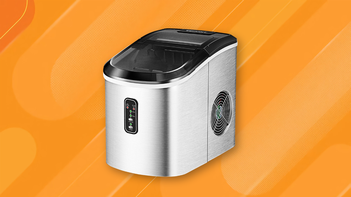 A stainless steel countertop ice maker with a digital display and side ventilation, set against an orange, gradient background with subtle patterns.