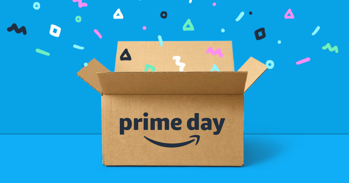 An open cardboard box with the 'Amazon Prime Day' logo displayed on the front. Colorful confetti-like shapes are flying out of the box against a bright blue background, symbolizing the excitement and celebration of Amazon's Prime Day shopping event.