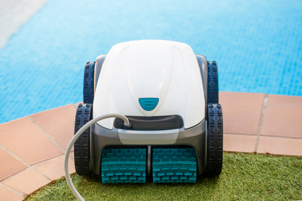 A robotic pool cleaner placed at the edge of a swimming pool, ready for use.