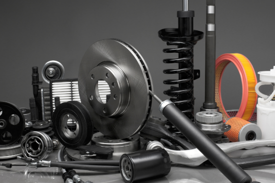 This image showcases an assortment of car parts, including brake discs, filters, suspension components, and other essential automotive accessories, against a dark backdrop.