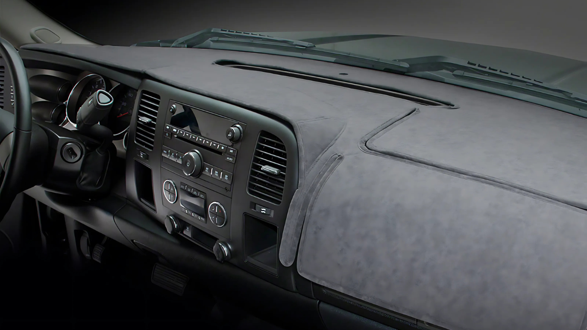 This image displays a car dashboard fitted with a custom suede-like dash cover, providing protection against sun damage and reducing glare.