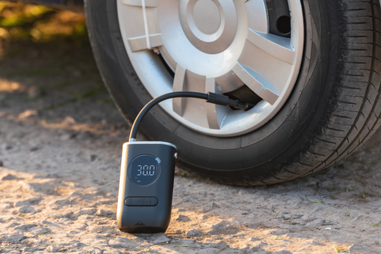 This image showcases a portable digital tire inflator connected to a car tire, displaying a pressure reading of 30.0 PSI.