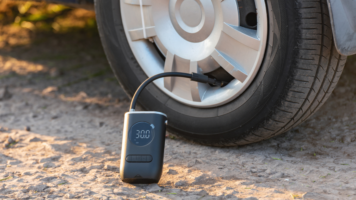 This image showcases a portable digital tire inflator connected to a car tire, displaying a pressure reading of 30.0 PSI.