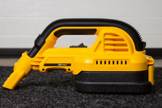 Portable yellow handheld vacuum cleaner with a flexible hose attachment, designed for easy use on carpets and small spaces.