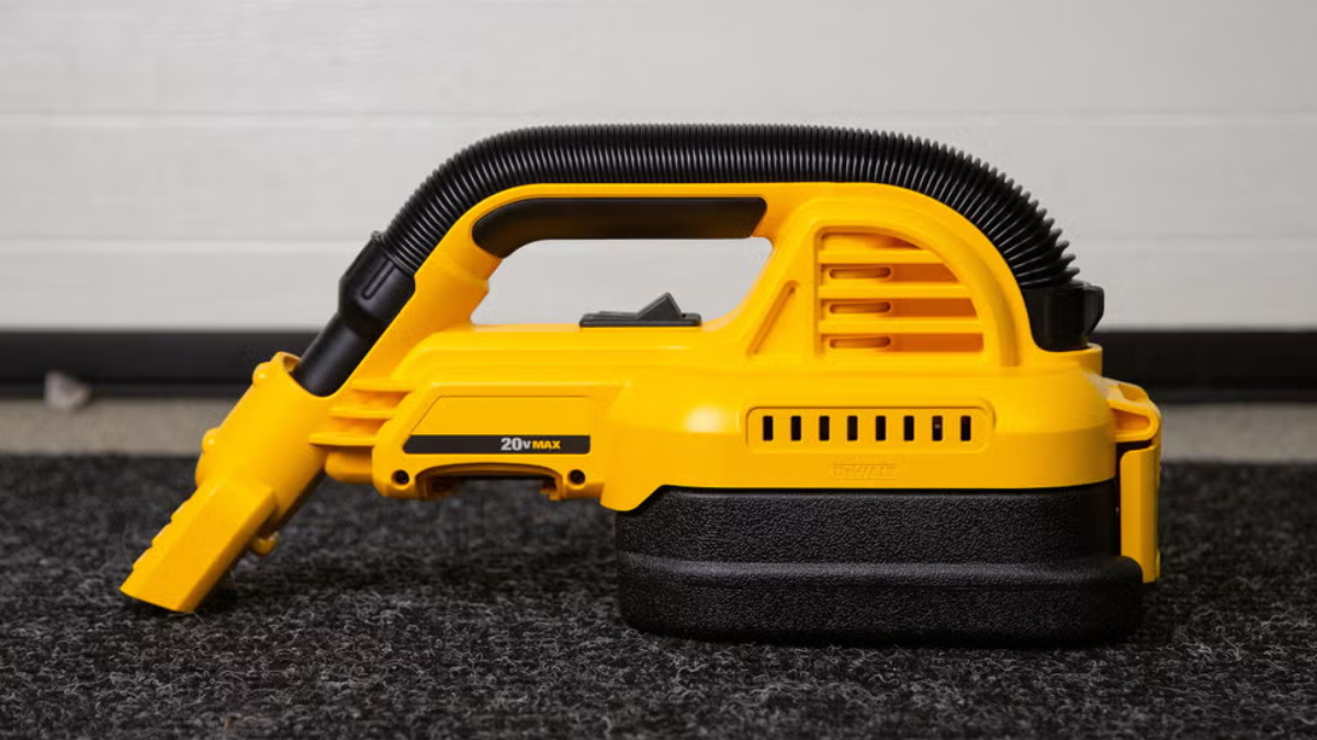 Portable yellow handheld vacuum cleaner with a flexible hose attachment, designed for easy use on carpets and small spaces.