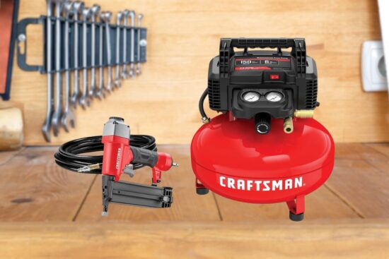 A red CRAFTSMAN air compressor with a black top, a brad nailer, and a coiled air hose on a wooden workbench with tools in the background.