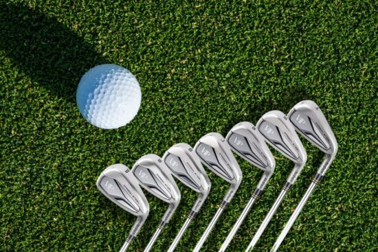 The MacGregor Golf VIP Iron Set 4-PW is lined up on green grass next to a golf ball, showing its clean and shiny design.