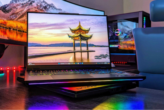 A Lenovo Legion Pro 7i Gen 9 gaming laptop on a desk, illuminated with vibrant RGB lighting and a scenic wallpaper on the screen.
