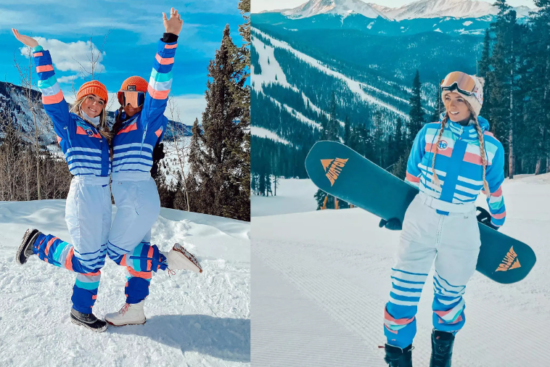 Two women in colorful blue and white ski outfits enjoying a snowy mountain setting; one is holding a snowboard, and the other is joyfully posing.