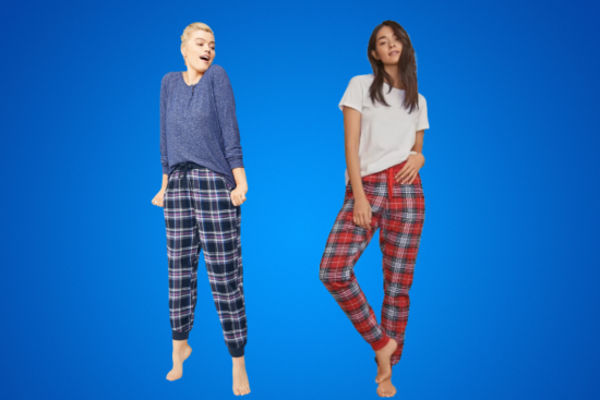 Two women wearing plaid pajama pants, one with a blue sweater and the other with a white T-shirt.