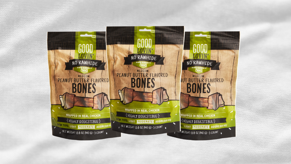 An assortment of colorful dog toys, a leash, and a bowl of bone-shaped treats arranged on a bright yellow background.