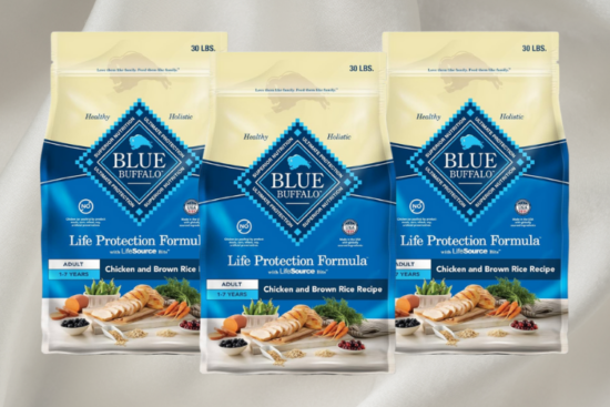 Three bags of Blue Buffalo Life Protection Formula dog food, featuring the Chicken and Brown Rice Recipe, displayed against a soft white fabric background.