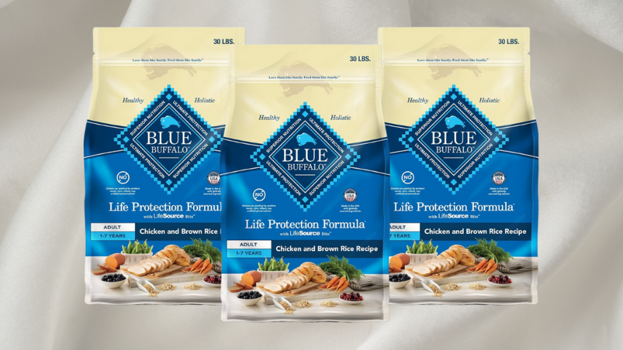 Three bags of Blue Buffalo Life Protection Formula dog food, featuring the Chicken and Brown Rice Recipe, displayed against a soft white fabric background.