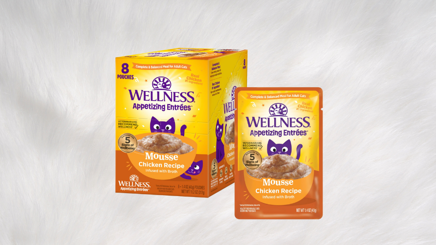 A box and pouch of Wellness Appetizing Entrées Mousse Chicken Recipe cat food, displayed against a soft white fur background.