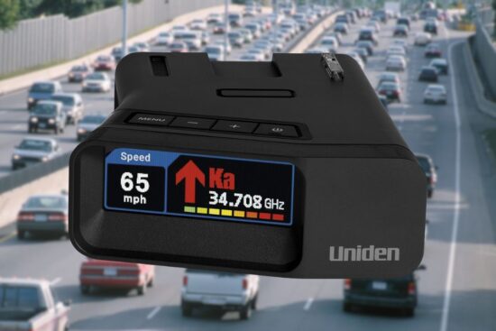 Uniden R7 radar detector displaying speed and signal on a busy highway.