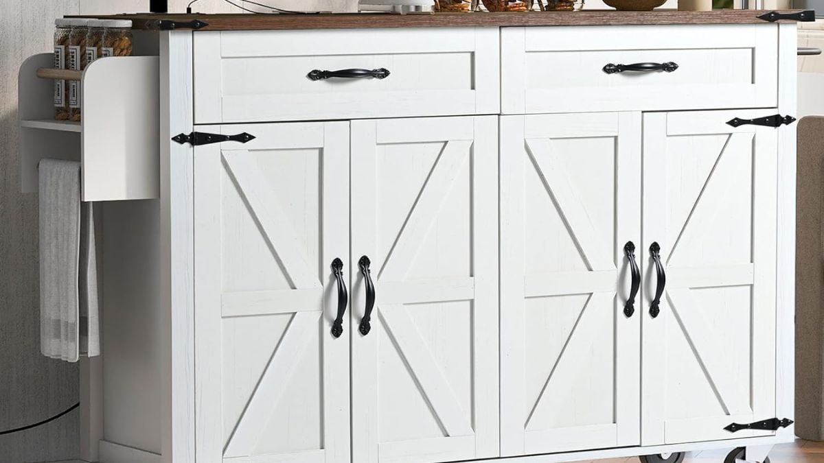 A white farmhouse-style rolling kitchen island with black metal handles, barn-style cabinet doors, drawers, a towel rack, and a spice shelf.
