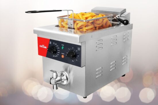 A stainless steel countertop electric deep fryer with a control panel, oil drain valve, and a frying basket filled with crispy onion rings and fries.