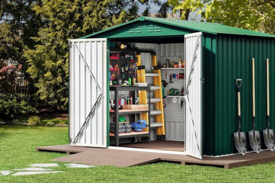 A green metal storage shed with open doors shows neatly organized tools, shelves, ladders, and three shovels hanging on the side.