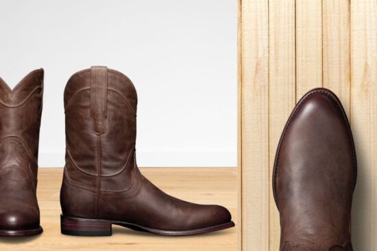 A pair of brown cowboy boots with a classic design, shown from different angles on a wooden floor.