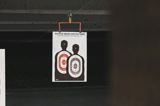Paper shooting targets hanging at an indoor range, often used for training with the Crosman Silhouette 1701P PCP Target Air Pistol.
