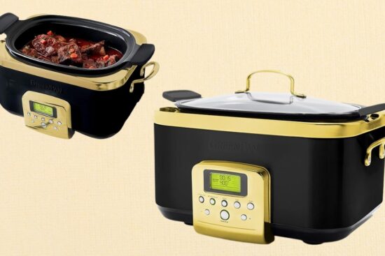 A black and gold slow cooker with a digital display, shown with a glass lid and an open view of cooked food inside.