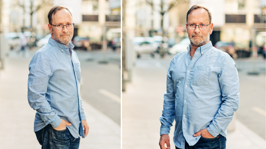 Older man wearing a light blue casual shirt outdoors.