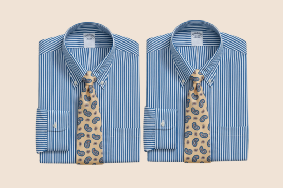 Two blue striped dress shirts folded with paisley ties.
