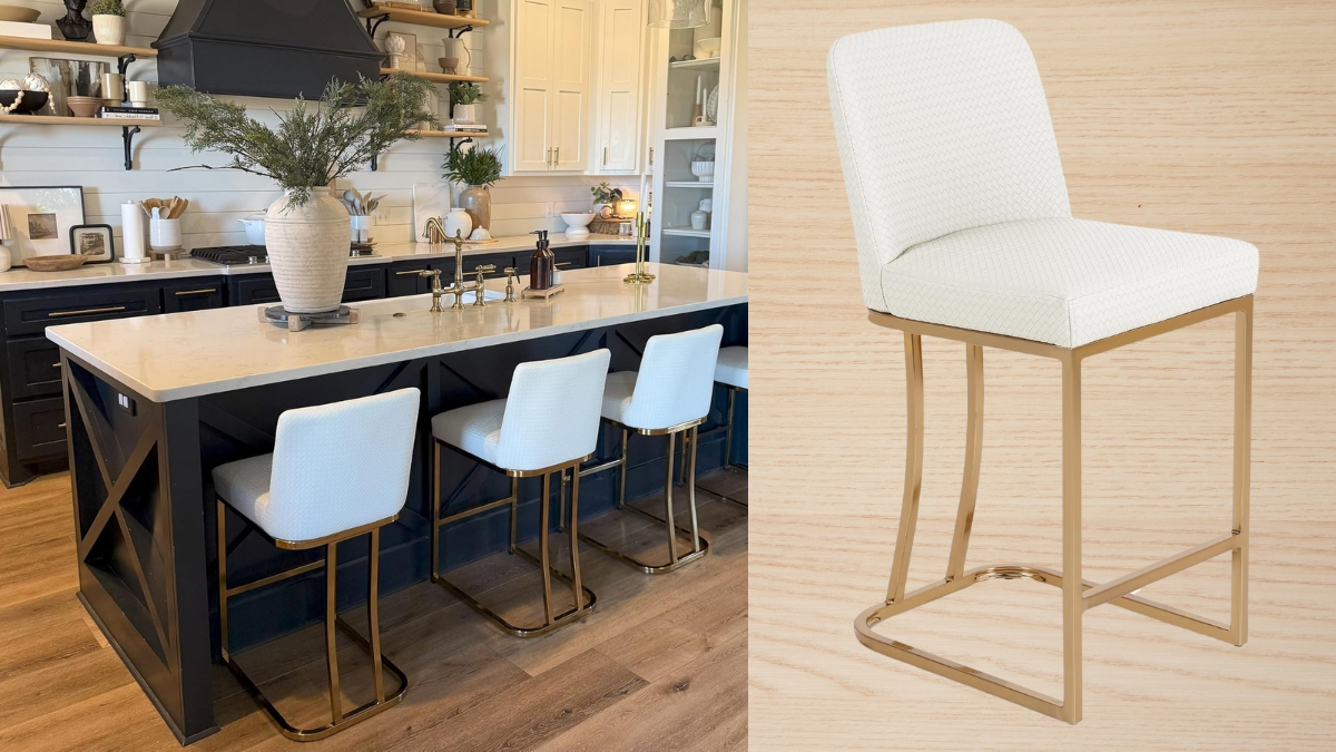 A modern kitchen with a black island features white kitchen bar stools with gold metal legs, a cushioned seat, and a curved back, adding elegance and comfort to the space.