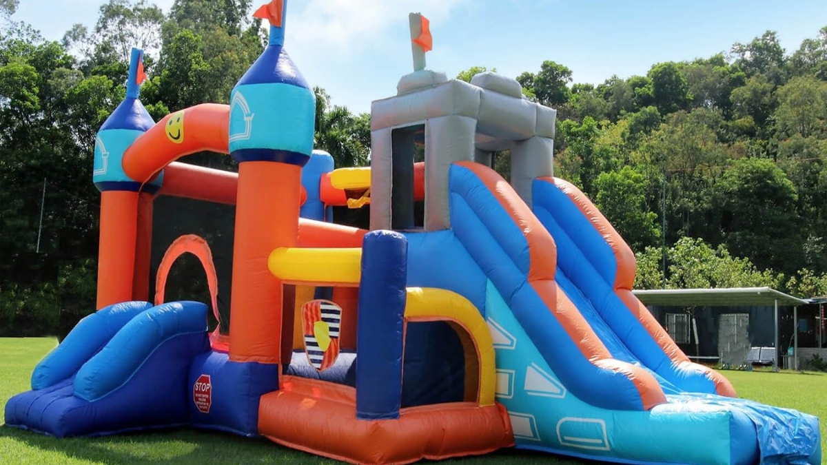 Colorful Inflantteble 16FT commercial kids bounce house with dual slides, climbing wall, and mesh sides set up on grass.