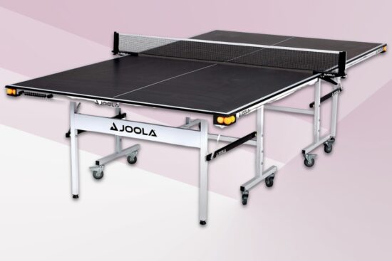Black JOOLA Rally TL indoor table tennis table shown fully set up with net, ball holders, and wheels for easy movement.