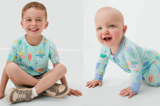 A smiling young boy in a mint green shirt with popsicle graphics, sitting cross-legged next to a crawling baby in a matching ice cream-themed onesie.