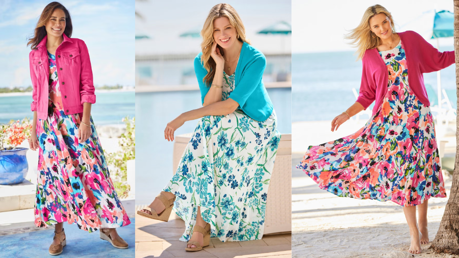 Three women wearing vibrant floral maxi dresses with cardigans, posing outdoors by the ocean.