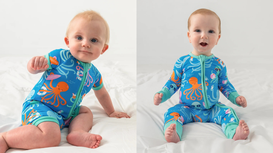 Two babies sitting on a white bed, each wearing blue pajamas with orange octopus and ocean-themed designs.