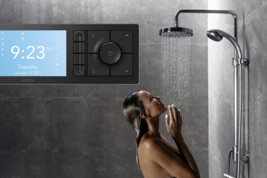 Woman enjoying a shower with water running from a smart shower system and a Moen Smart Shower Controller Matte Black on the wall.