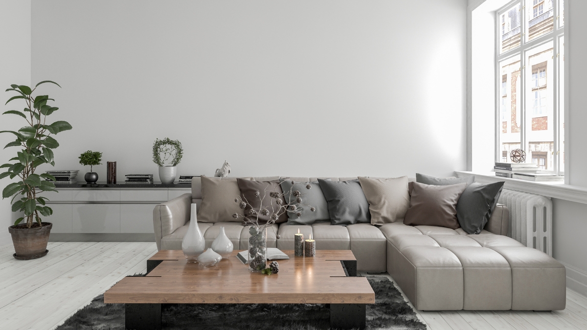 Beige modern modular sofa with tufted seats, neutral throw pillows, and a wood coffee table in a bright living room.