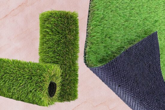 Close-up of a rolled artificial grass rug showing the green turf surface and durable black backing.