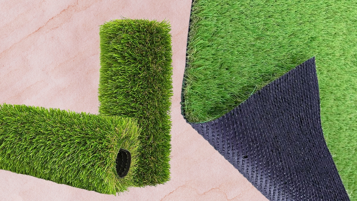 Close-up of a rolled artificial grass rug showing the green turf surface and durable black backing.