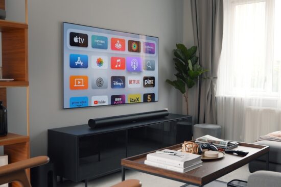 Flat-screen TV with streaming apps displayed above a Sony soundbar in a modern living room.