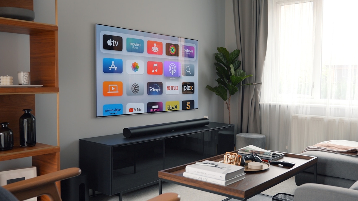 Flat-screen TV with streaming apps displayed above a Sony soundbar in a modern living room.