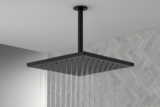 Black square rain shower head with water flowing evenly, mounted on a ceiling in a tiled modern bathroom.
