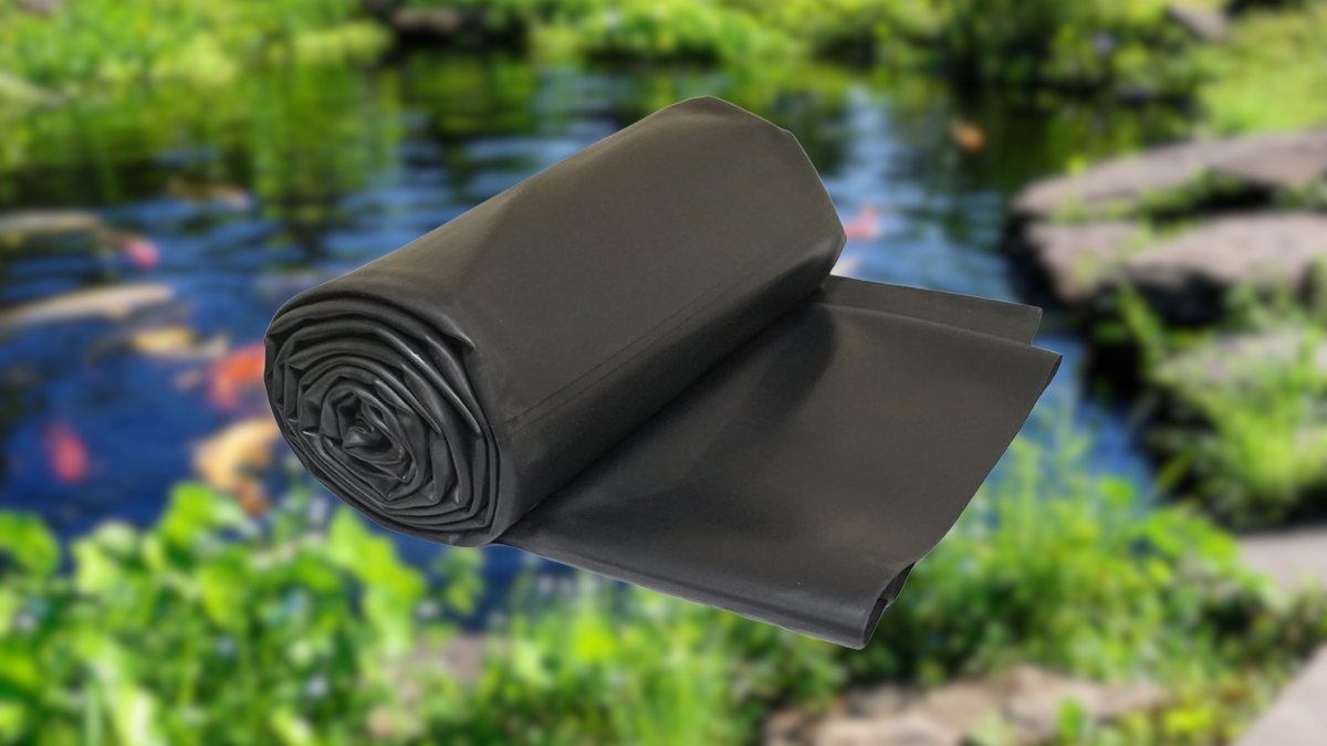 Lifeguard EPDM Pond Liner rolled up in front of a backyard fish pond with rocks and plants.