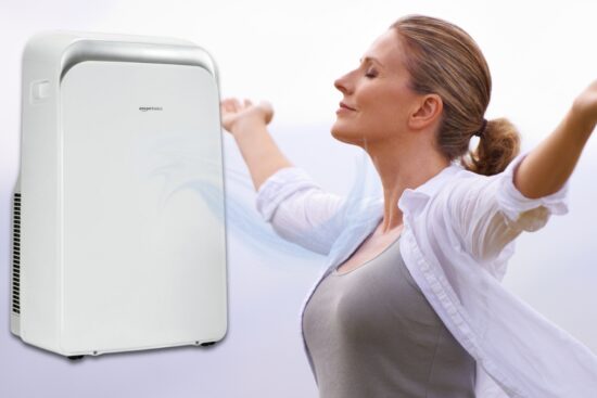 Woman enjoying fresh air near a portable air conditioner with heat from Amazon Basics.