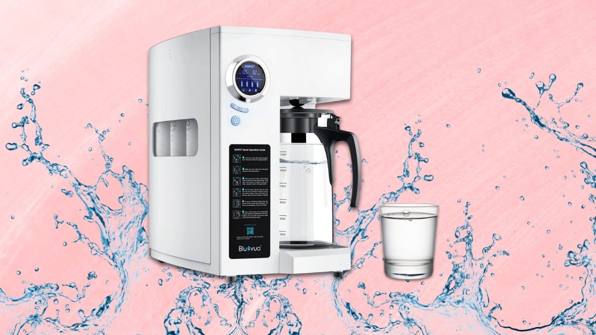 A countertop reverse osmosis system with a glass carafe and control panel, shown dispensing clean filtered water next to a full glass.