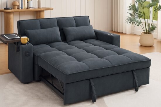 Dark gray convertible sofa bed with cup holder and side tray set in a bright living room with wooden floor and potted plant.