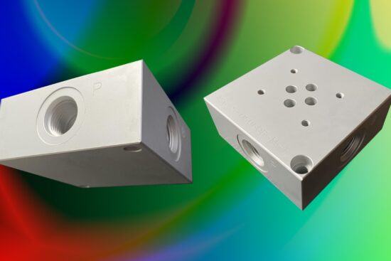 Two aluminum hydraulic valve mounting sub plates with SAE 8 ports shown against a colorful background.