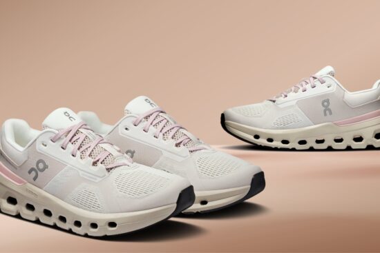 On Cloud running shoes in beige and pink colorway displayed on a neutral background.